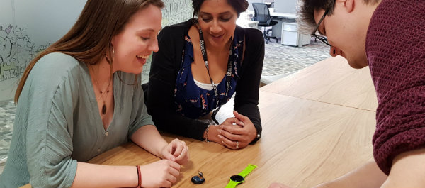 Three Digital Health students examining a wearable